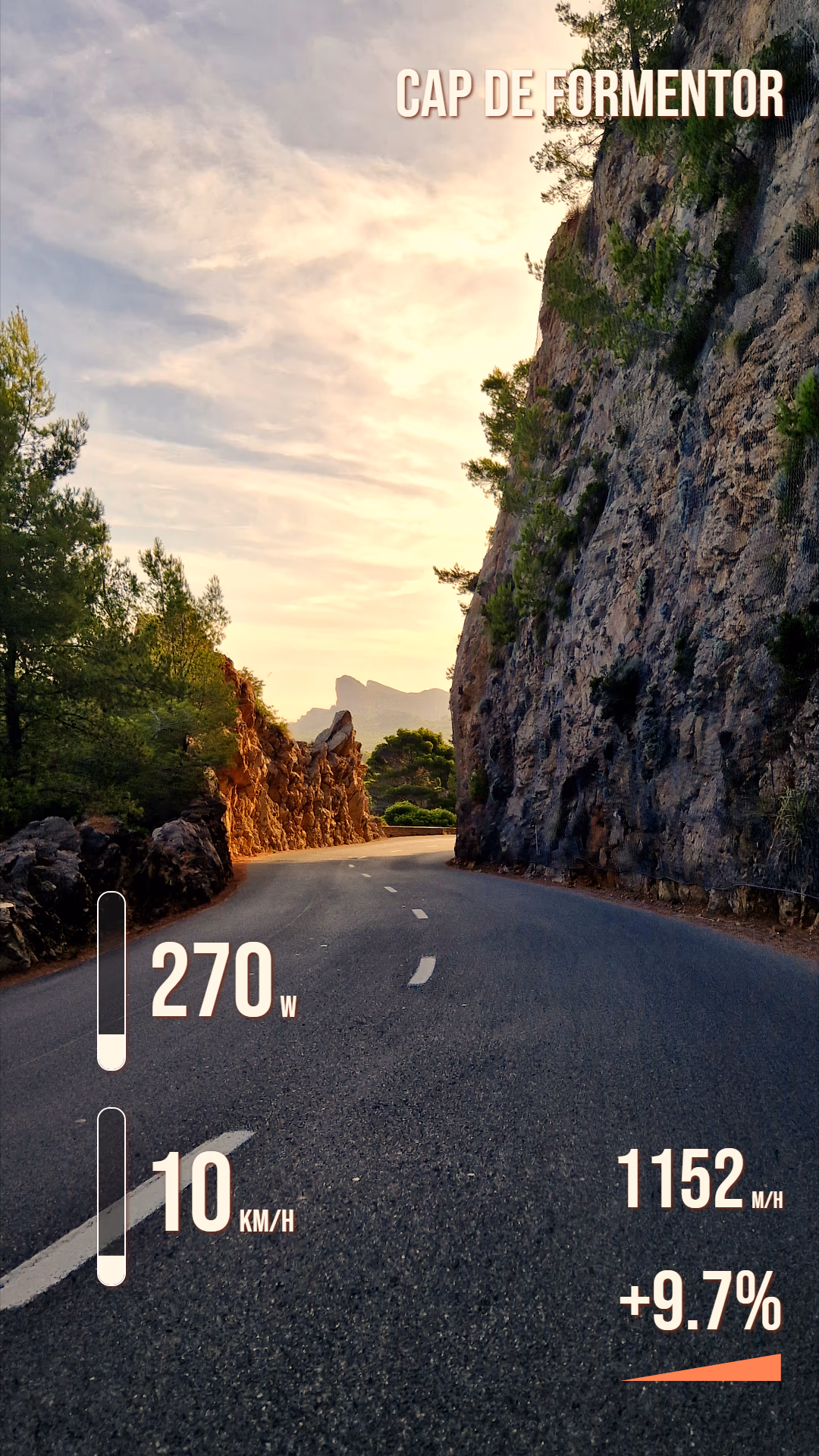 Portrait coastal road footage with location, power, speed, elevation, and gradient widgets.