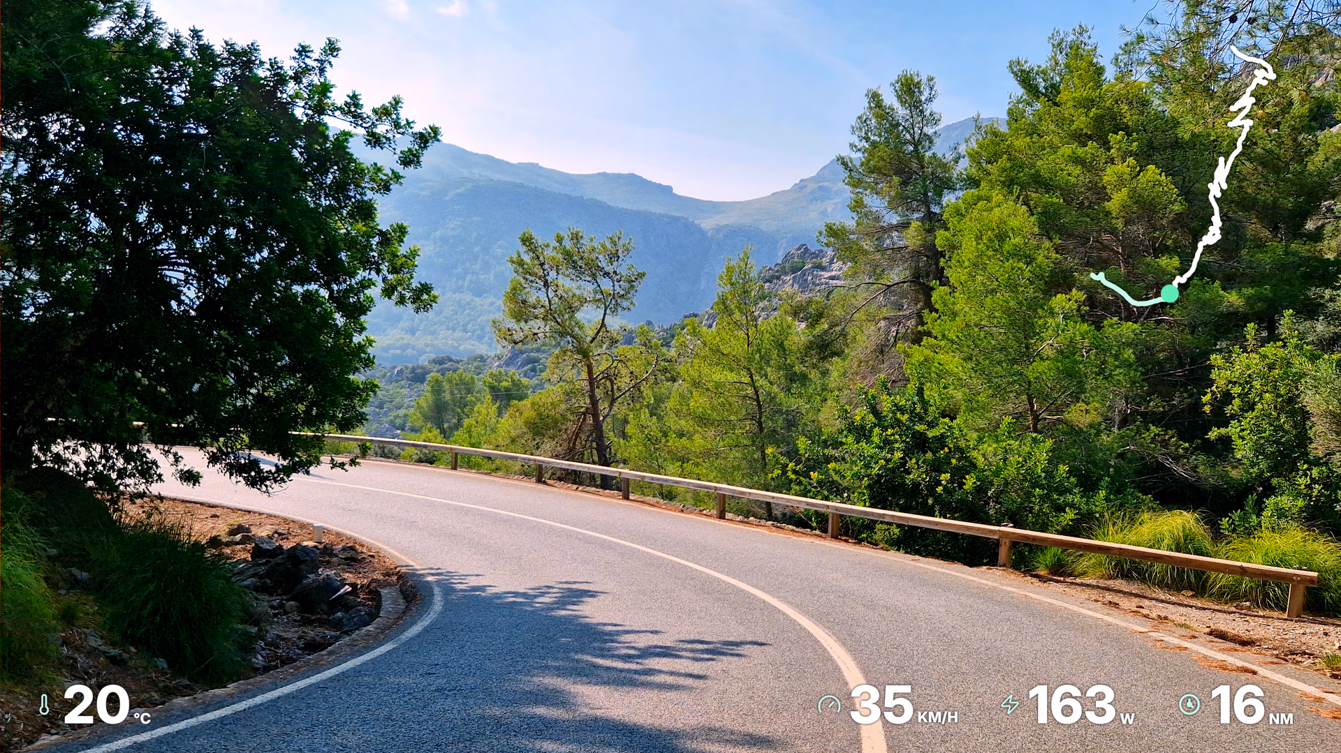 Mountain road footage with route, temperature, speed, power, and distance widgets.